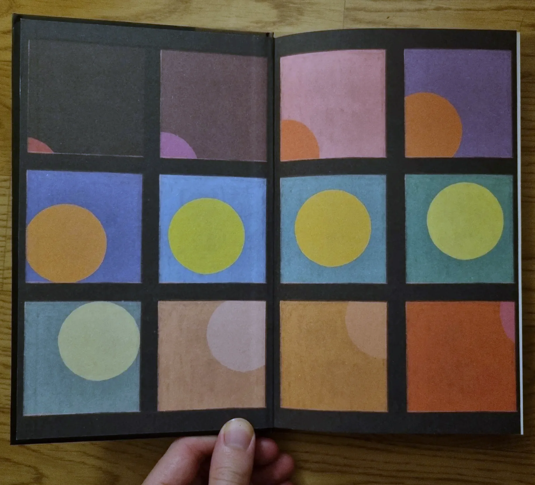 The Waterstones exclusive endpapers: twelve panels, four across and three down, each a coloured square holding a sun disc in a different position and hue